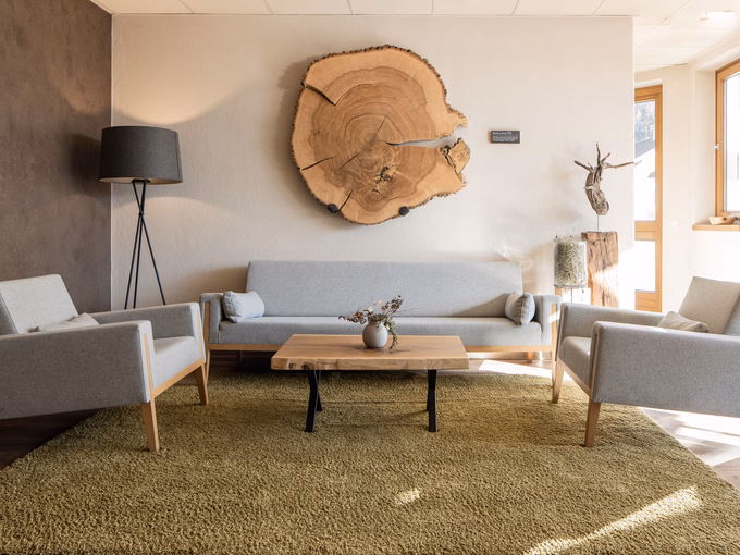 Der großzügige Loungebereich mit modernen Sitzmöbeln und alpinen Holzelementen im Naturhotel Outside in Matrei in Osttirol.
