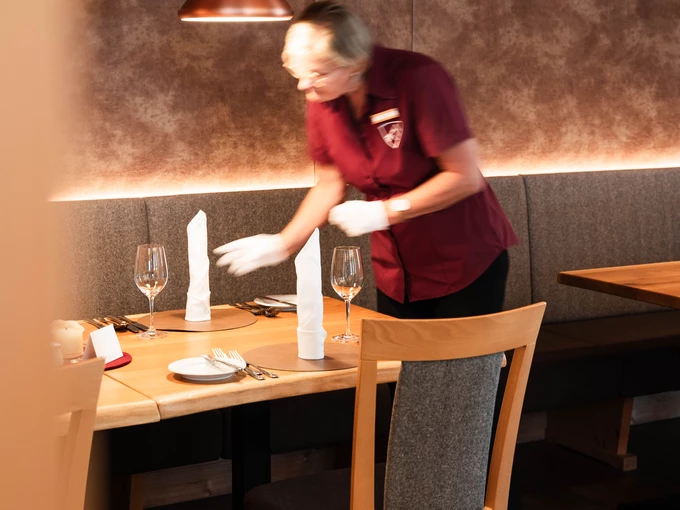 Kellnerin deckt Tisch auf
