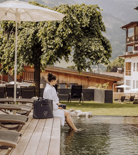 Frau sitzt am Naturpool