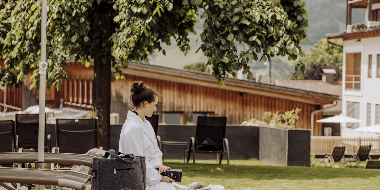 Frau sitzt am Naturpool