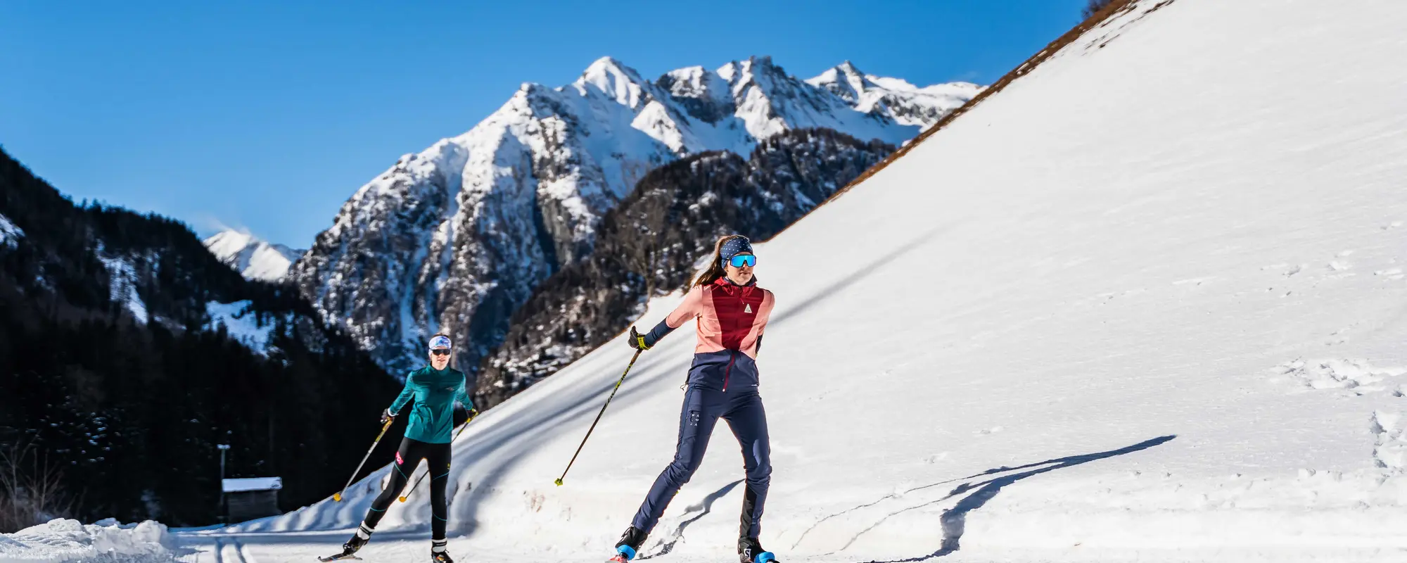 Zwei Langläuferinnen skaten durch herrliche Winterlandschaft