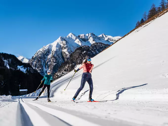 Zwei Langläuferinnen skaten durch herrliche Winterlandschaft