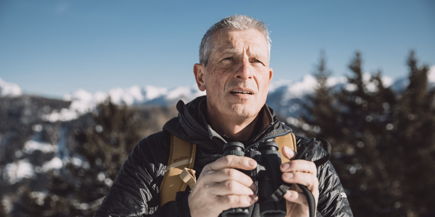 Ranger mit Fernglas in Winterlandschaft