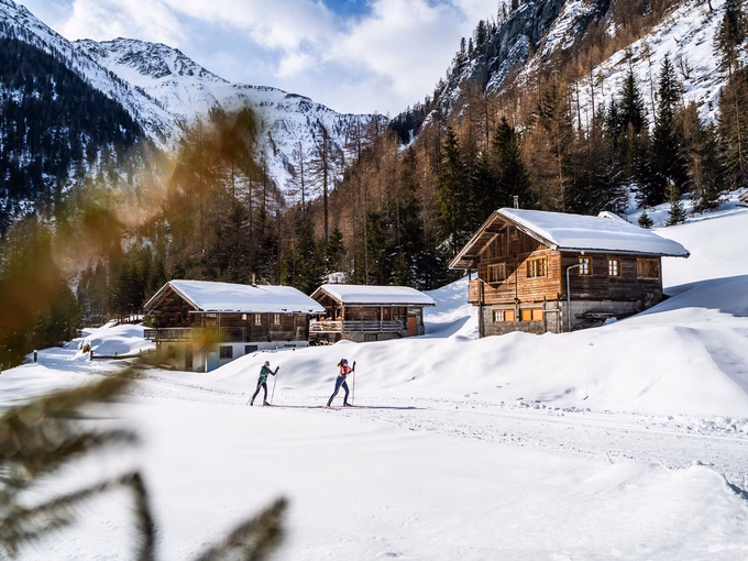 Langläufer skaten durch verschneites Almdorf