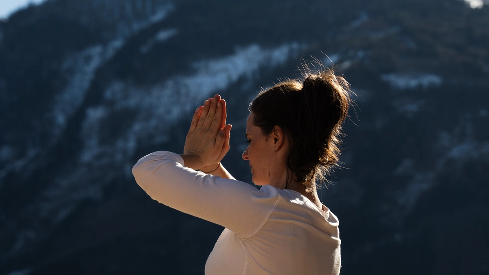 Frau macht Yoga mit Bergblick im SPA Garten