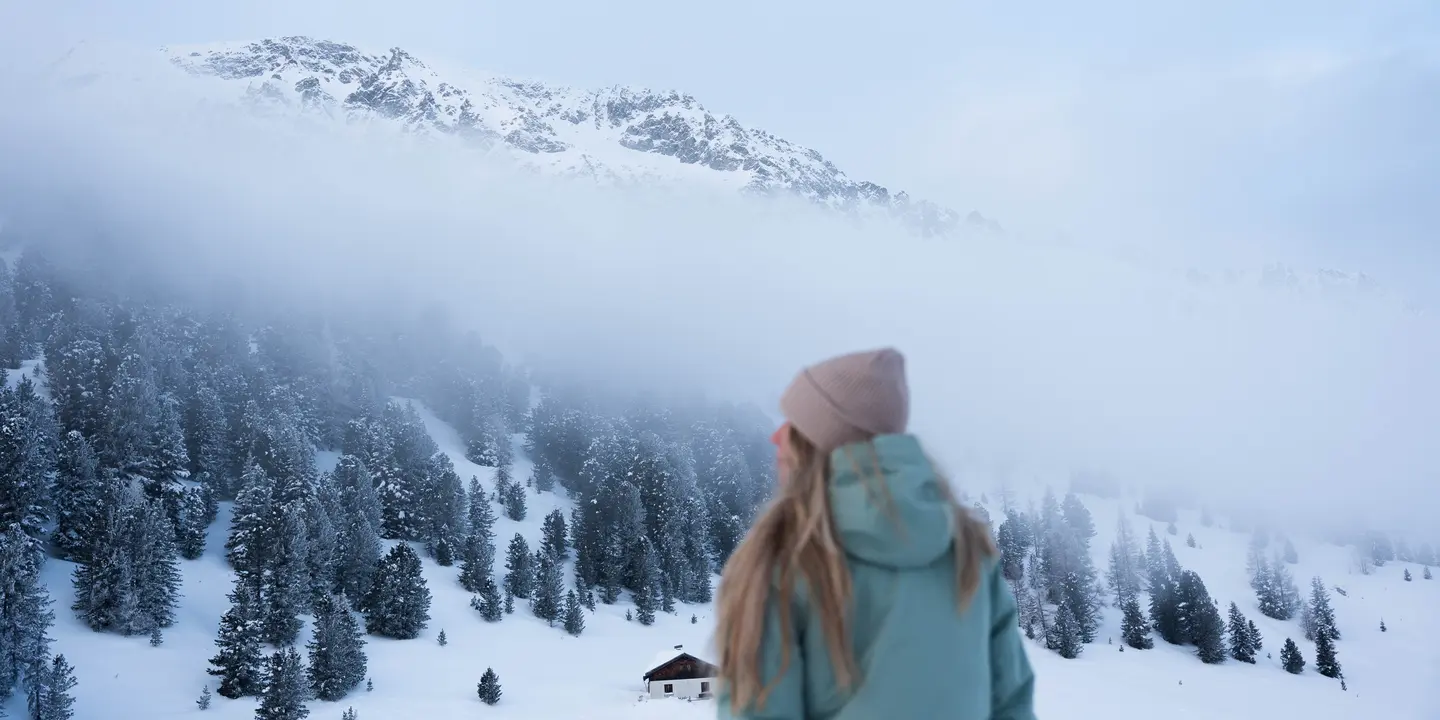 Frau in verschneiter Winterlandschaft in den Bergen