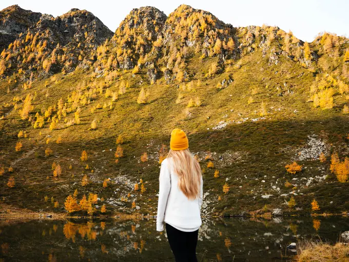 Frau steht am Gebirgssee