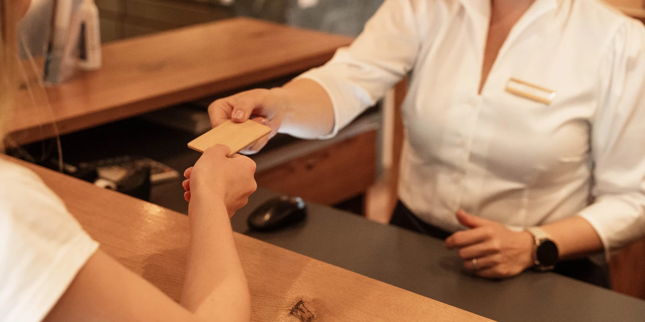 Barbara übergibt Gast die Zimmerkarte