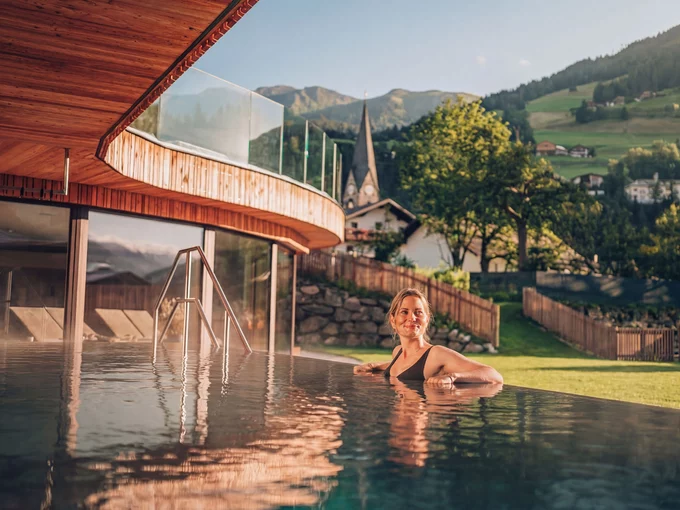 Frau liegt im Pool und genießt die Sonne