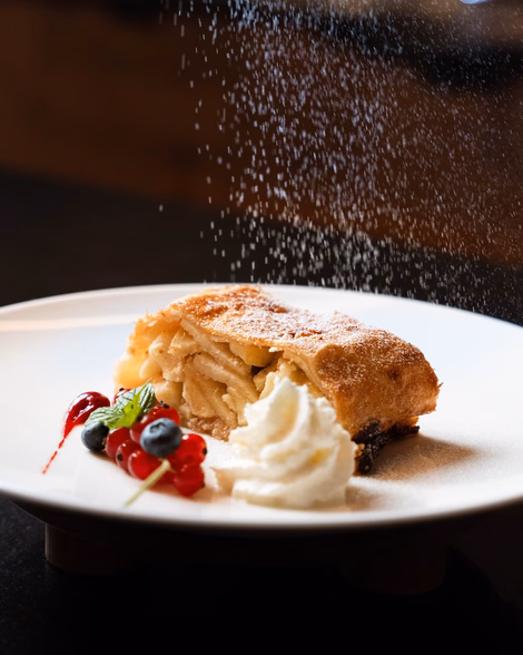 Hausgemachter Apfelstrudel mit Puderzucker, Sahne und Beeren garniert im Naturhotel Outside in Matrei in Osttirol