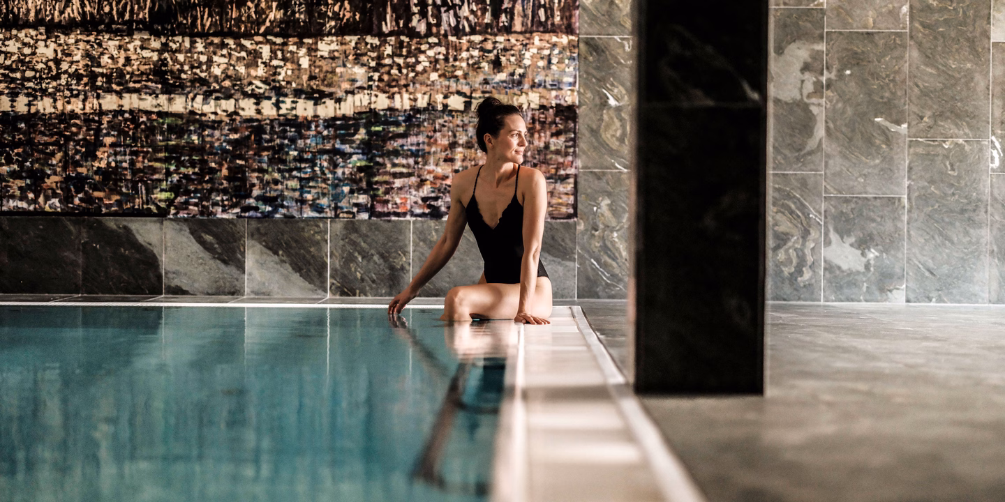 Dame sitzt am Hotelpool