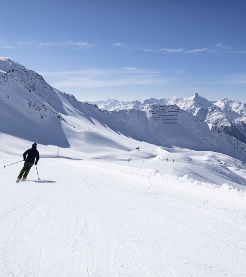 Skifahrer fährt im Großglockner Resort über Piste talwärts