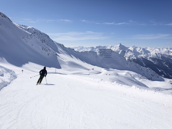 Skifahrer fährt im Großglockner Resort über Piste talwärts