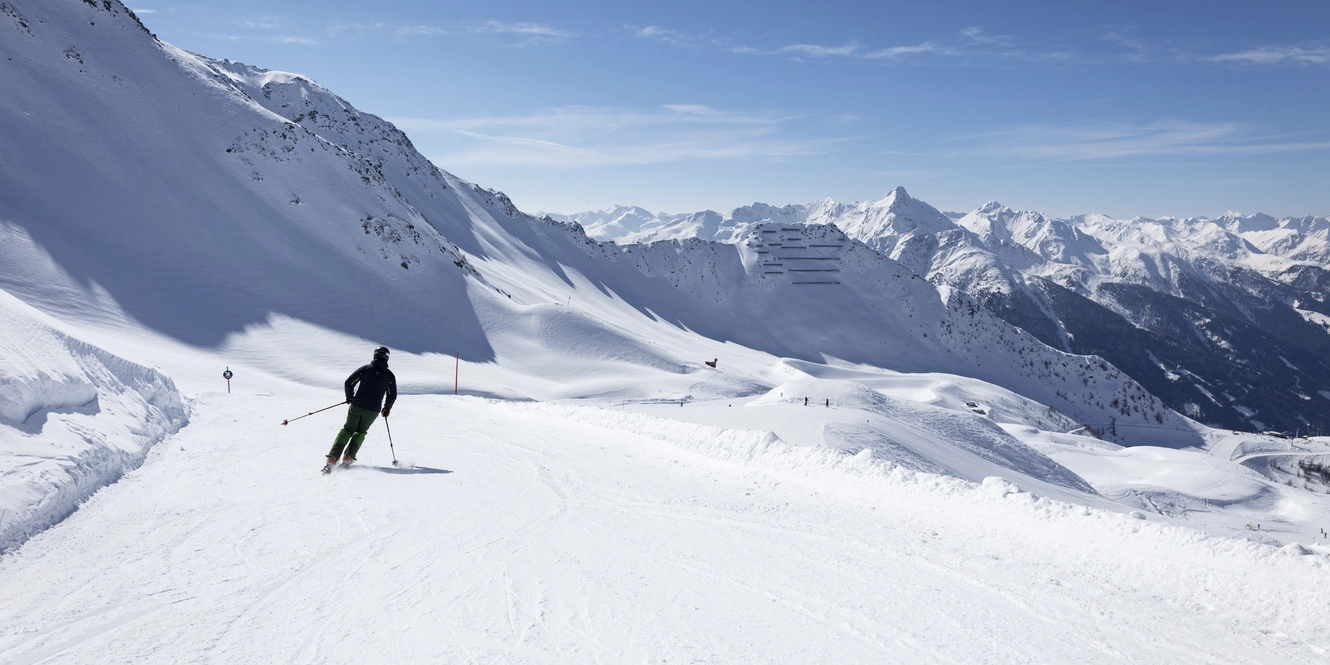 Skifahrer fährt im Großglockner Resort über Piste talwärts