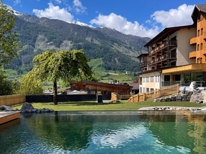 Der glasklare Naturteich und die gepflegte Gartenanlage vom Naturhotel Outside in Matrei in Osttirol.
