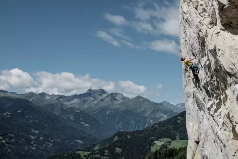 Mann klettert auf steilem Fels im Klettergarten Falkenstein