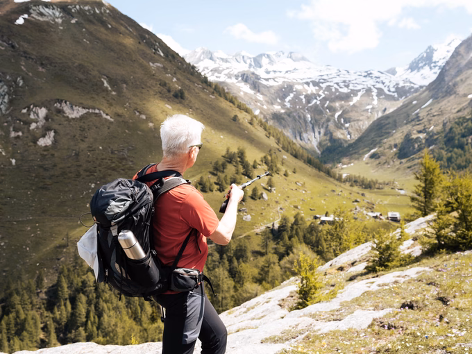 Wanderführer Sepp zeigt mit dem Wanderstock in Richtung der Steineralm beim Naturhotel Outside in Matrei in Osttirol.