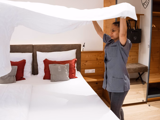 Eine Housekeeping-Mitarbeiterin bezieht ein Bett im Naturhotel Outside in Matrei in Osttirol.