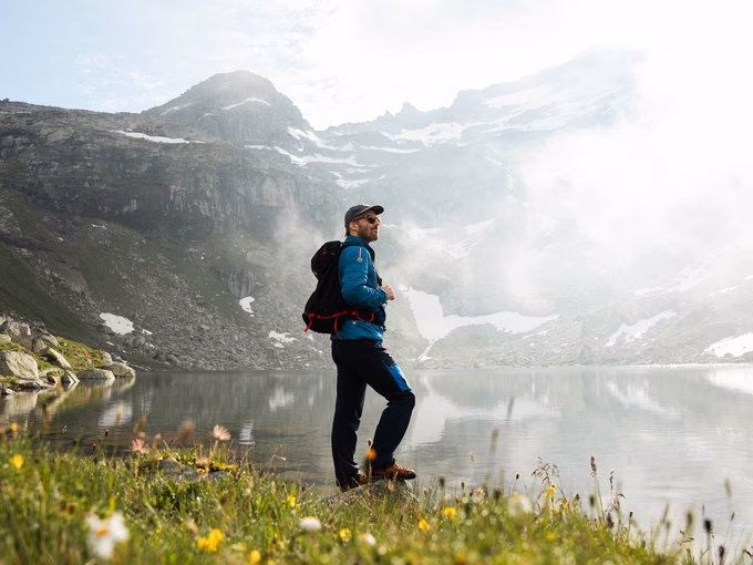 Wanderer steht am Bergsee