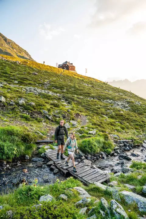 Zwei Wanderer auf kleiner Brücke unter der Lasörlinghütte
