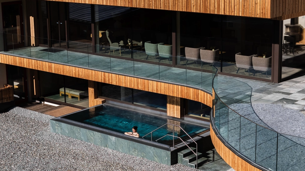Frau im Pool genießt die Sonnenstrahlen