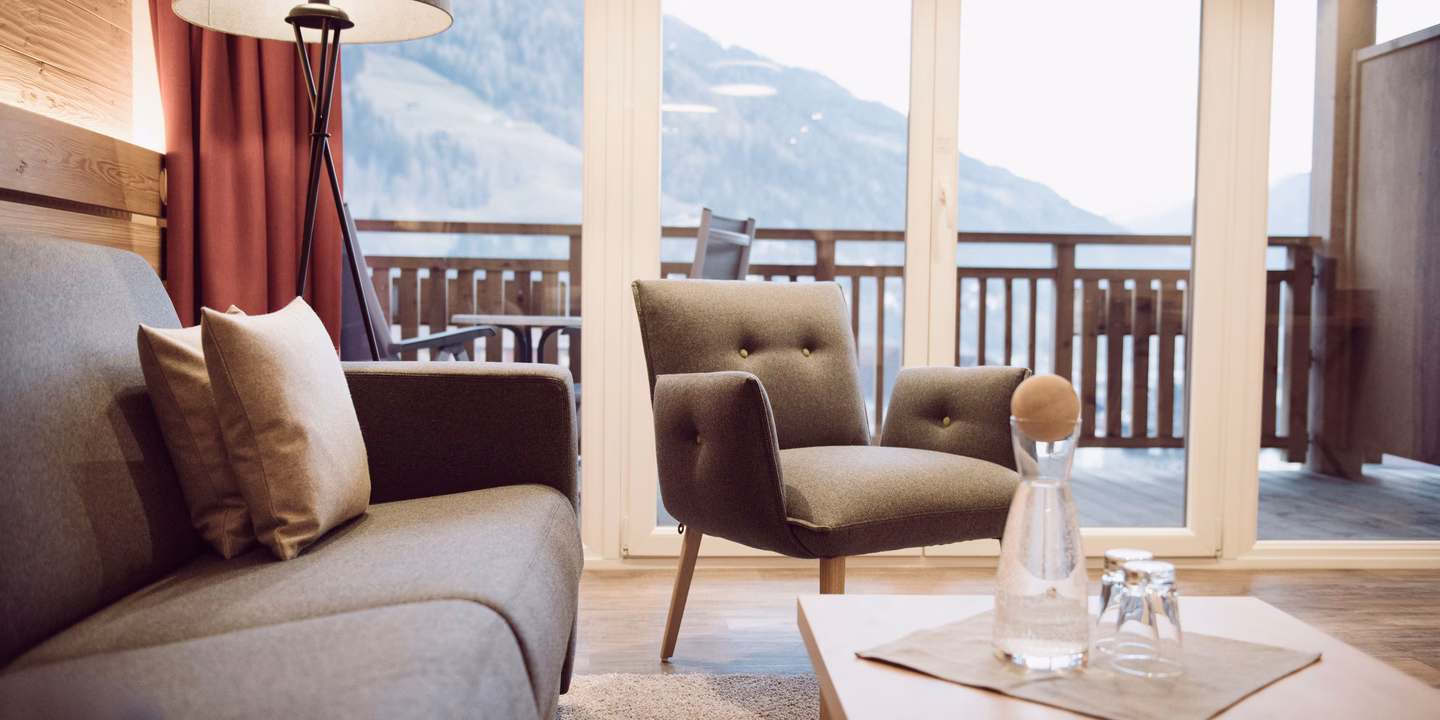Gemütliche Sitzecke in der Natursuite und Couchtisch mit Wasserkaraffe und Trinkgläsern