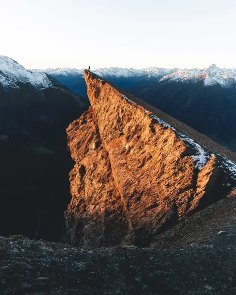 Wanderer steht auf Bretterwandspitze und genießt Gipfelpanorama