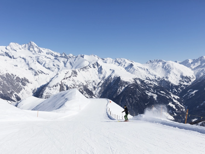 Skifahrer carvt über leere Piste