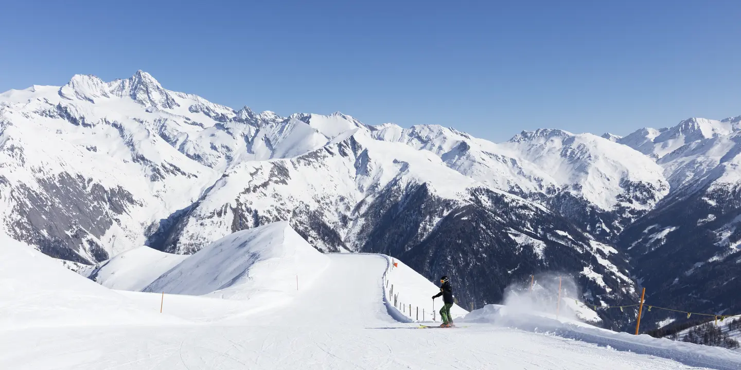 Skifahrer carvt über leere Piste