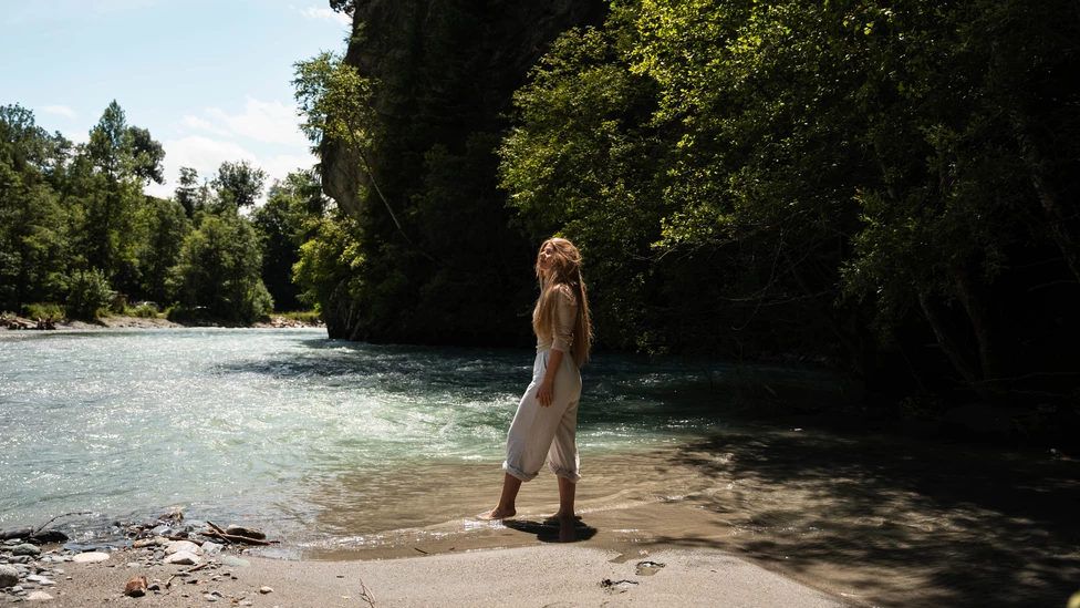 Frau genießt Fußbad im Gebirgsbach