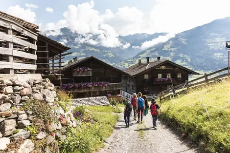 Erwachsene und Kinder wandern durch idyllisches Almdorf in Osttirol