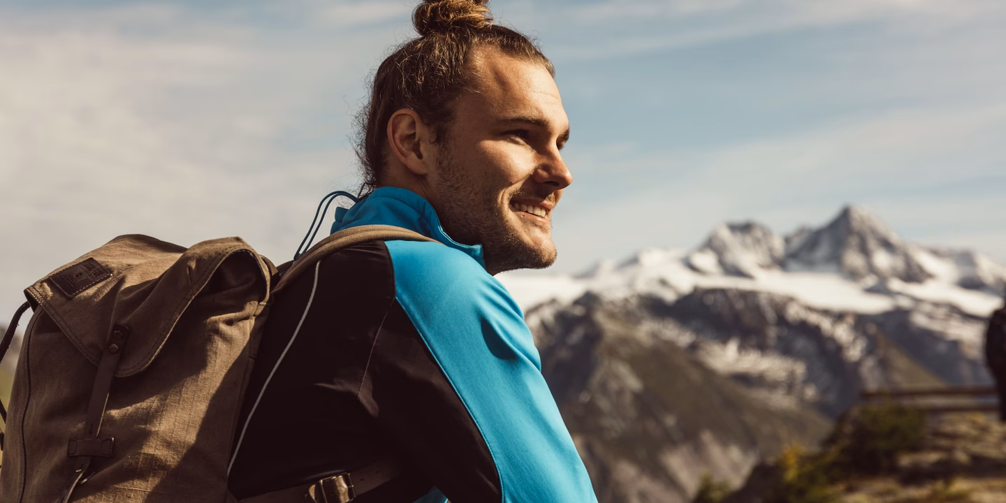 Wanderer genießt Ausblick auf den Großglockner und viele andere Gipfel