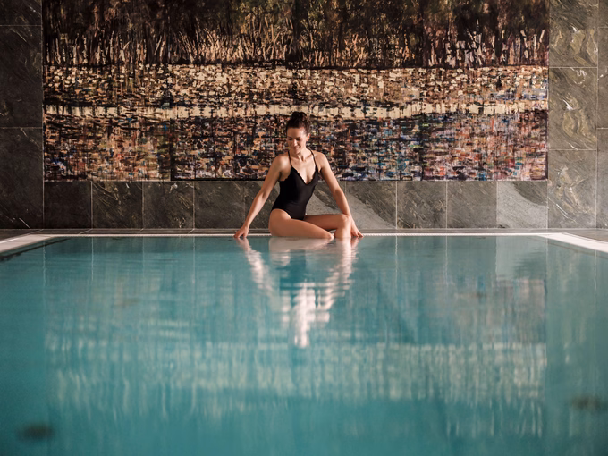 Dame sitzt am Hotelpool