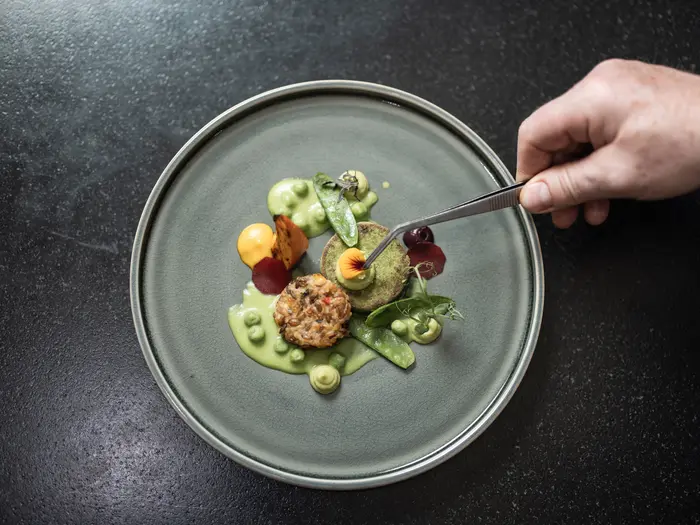 Koch vollendet Vorspeise mit Dekoblume