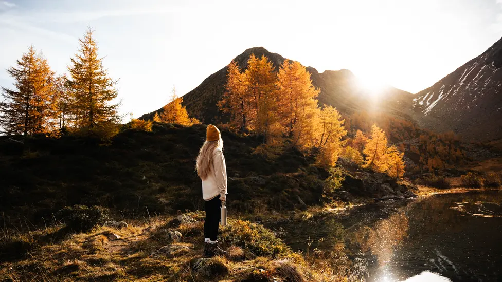 Frau steht am Bergsee