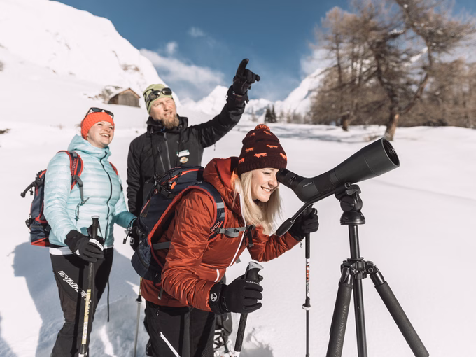 Schneeschuhwanderer beobachten die Wildtiere durch Spektiv