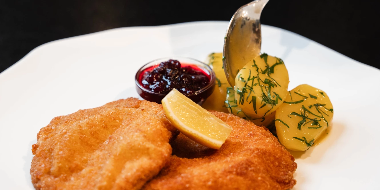 Klassisches Wiener Schnitzel mit Pertersilienkartoffel und Preiselbeeren
