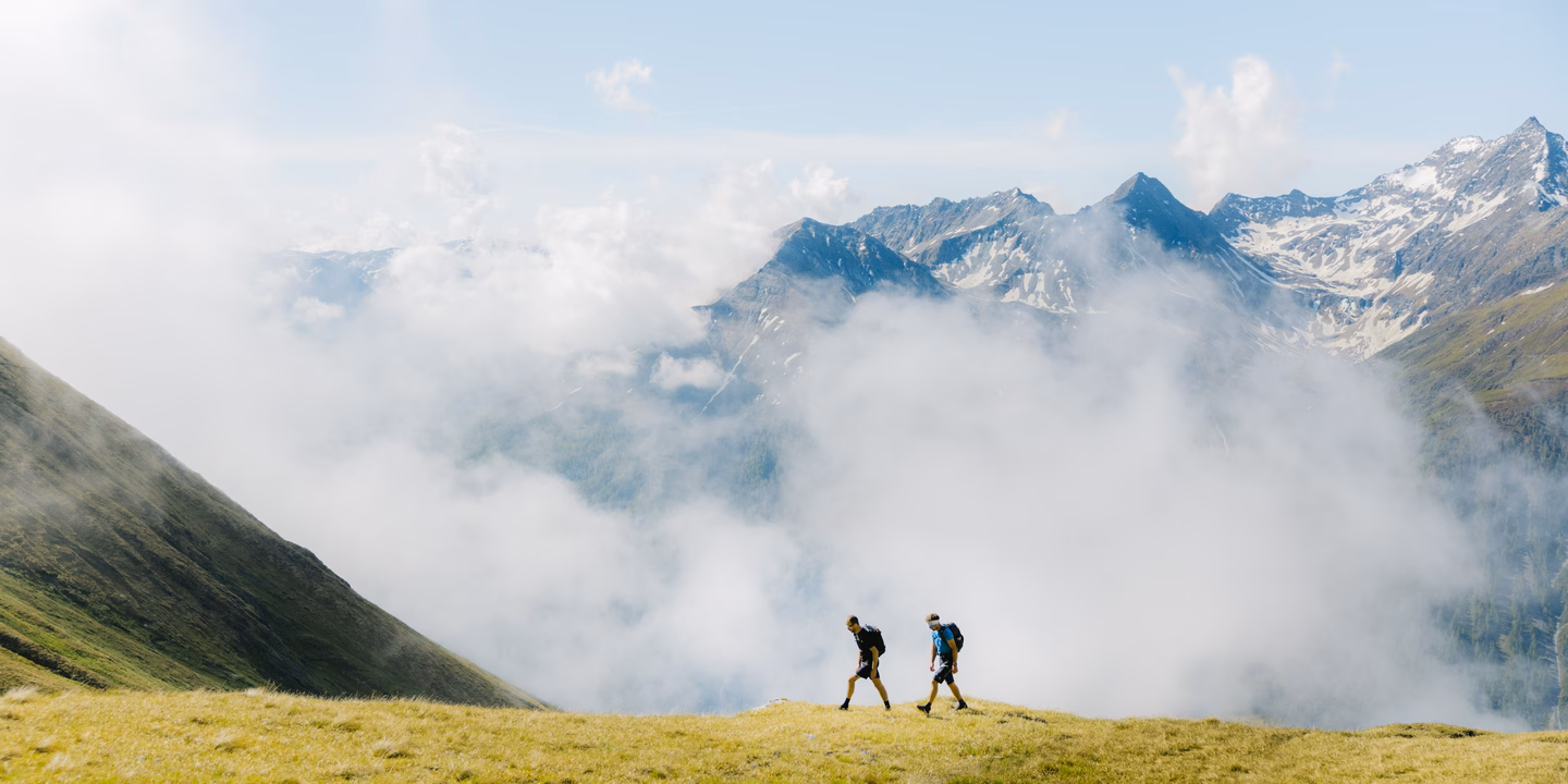 Wanderer auf Almwiese im Hintergrund Hochnebel