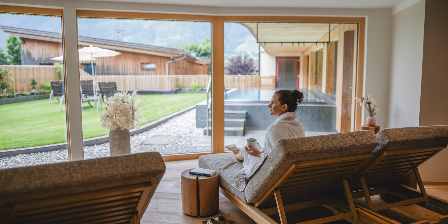 Frau mit Tee auf der Relaxliege im Ruheraum