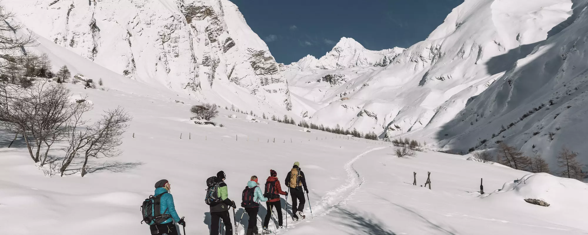Schneeschuhwanderer gehen mit Guide bergwärts 